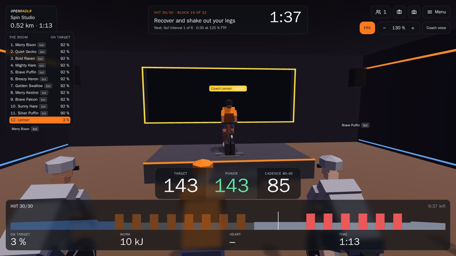 The OpenRadlr spin studio: Coach Lemon on stage, riders side by side, the room board and the class plan with target and power.